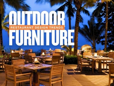 Outdoor restaurant furniture setup at a beachfront patio with wood tables and chairs, showcasing 2025 design trends for commercial dining spaces