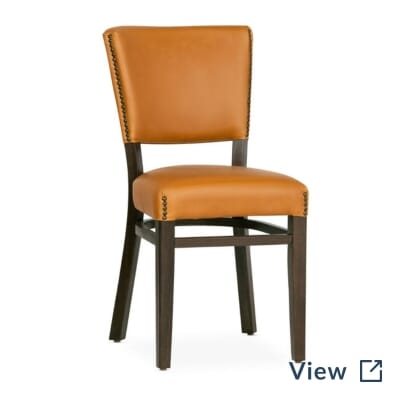 Fully upholstered beech wood Bennett restaurant chair with custom vinyl and brass accent nailhead trim.