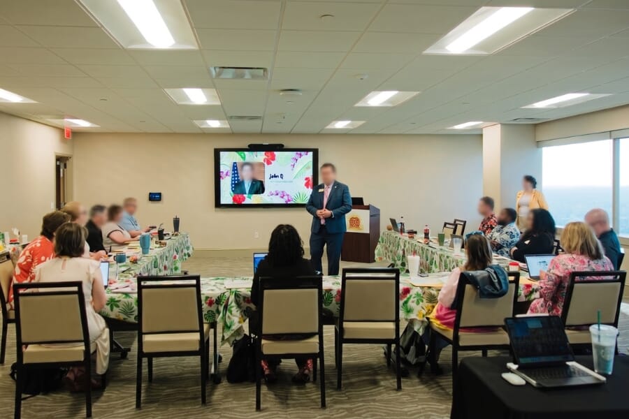Atticus stackable hospitality chairs arranged around black-draped tables for a U-shaped board meeting at the Charter Institute at Erskine.