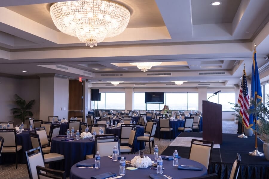 Charter Institute at Erskine conference event using Atticus black steel stackable banquet chairs with beige vinyl upholstery in a ballroom-style layout.