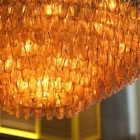 Close view of MARCUS DC bar seating with brass footrests and warm upholstery tones.