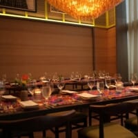 MARCUS DC dining room with table settings and a glowing statement chandelier.