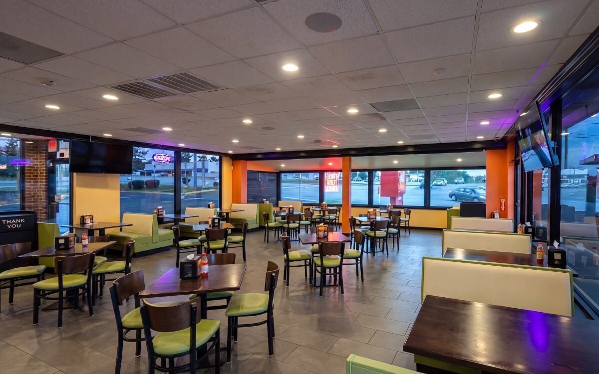 Braza Chicken restaurant interior with booth seating and walnut tables