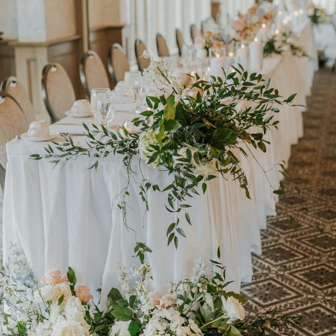 Rush Creek Golf Club MacMillan Ballroom in Maple Grove Minnesota featuring Eliseo teardrop-back banquet chairs with neutral upholstery and Bronze Sparkle aluminum frames arranged for a wedding reception.