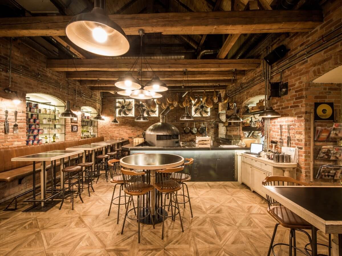 A rustic industrial-style restaurant interior with exposed brick walls, wooden beams, and modern furnishings, reflecting top social media marketing trends for 2025.