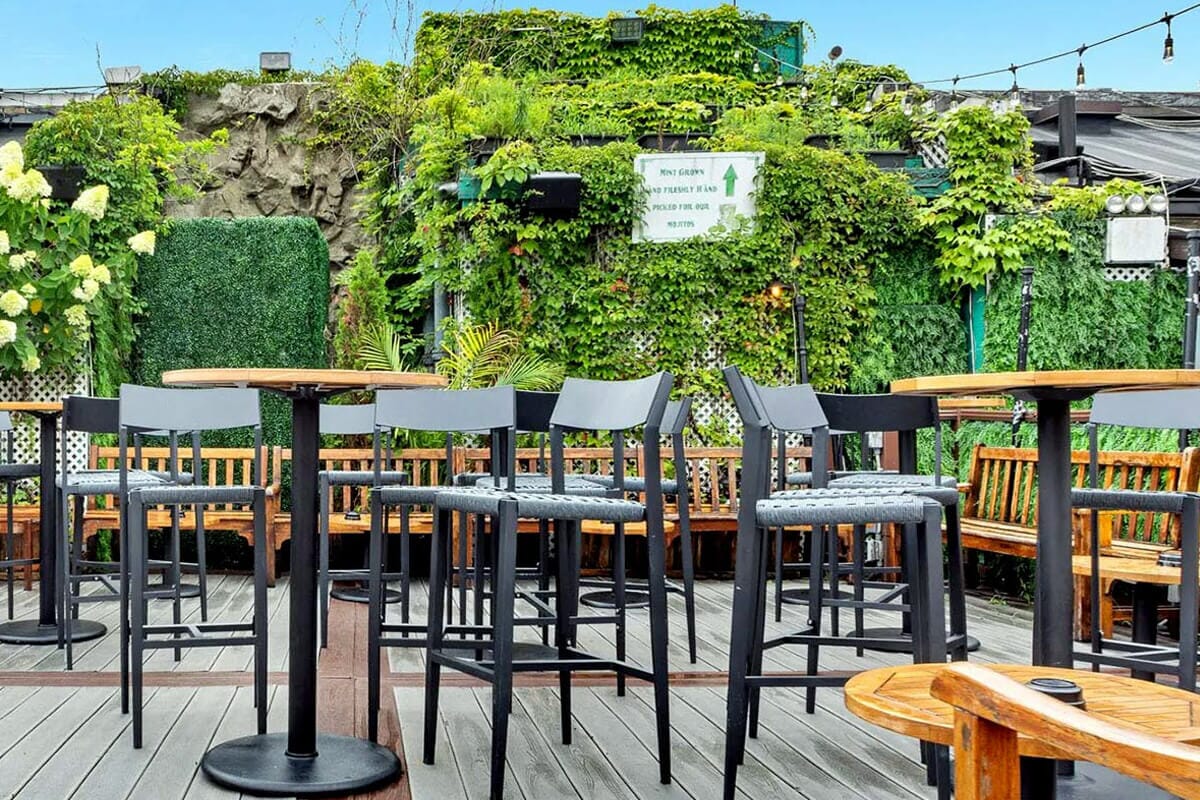 Panoramic rooftop patio at 230 Fifth in NYC, offering skyline views, stylish outdoor seating, and a vibrant nightlife atmosphere.