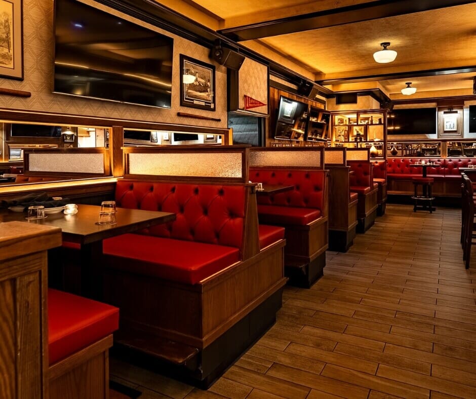 Custom red tufted restaurant booths at Central Park Tavern in New York City with mid-century inspired décor