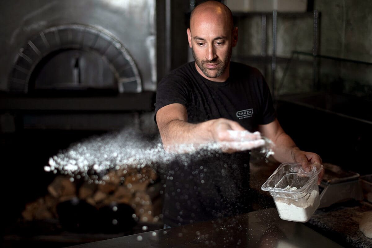 Chef Dan Richer at Razza in Jersey City, NJ, crafting artisanal, wild yeast-fermented pizza dough, renowned for its locally sourced ingredients and expert technique.