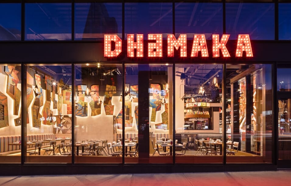 The entrance of Dhamaka restaurant, prominently displaying its name, represents the audacious and authentic Indian dining experience in New York City