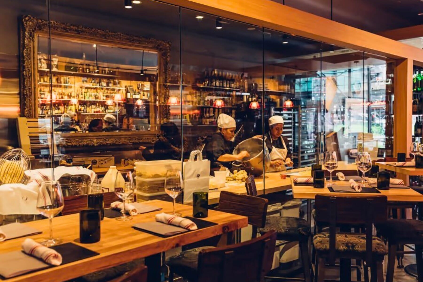 Walnut-finish restaurant table tops alongside a marble-look sintered stone surface — commercial table top options for Italian restaurant dining rooms