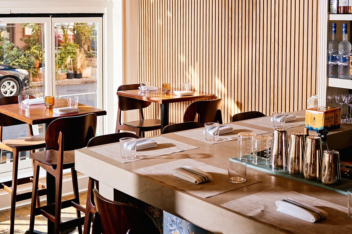 Interior of Little Walter's in Philadelphia, Pennsylvania, showcasing a modern take on Polish cuisine with cozy wooden tables and dim lighting for an inviting dining experience.