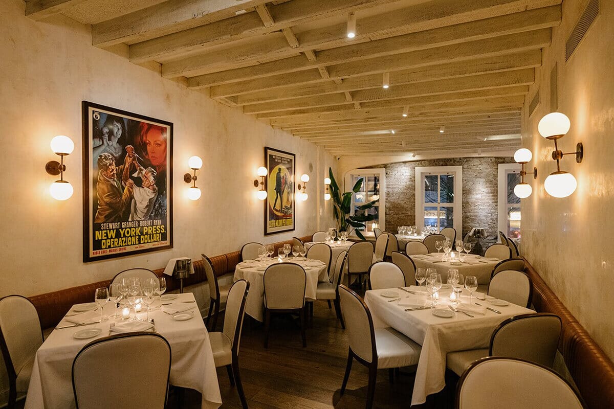 Restaurant interior of MAMO in Soho, New York featuring elegant white tablecloths and chairs, exuding a charming Italian ambiance