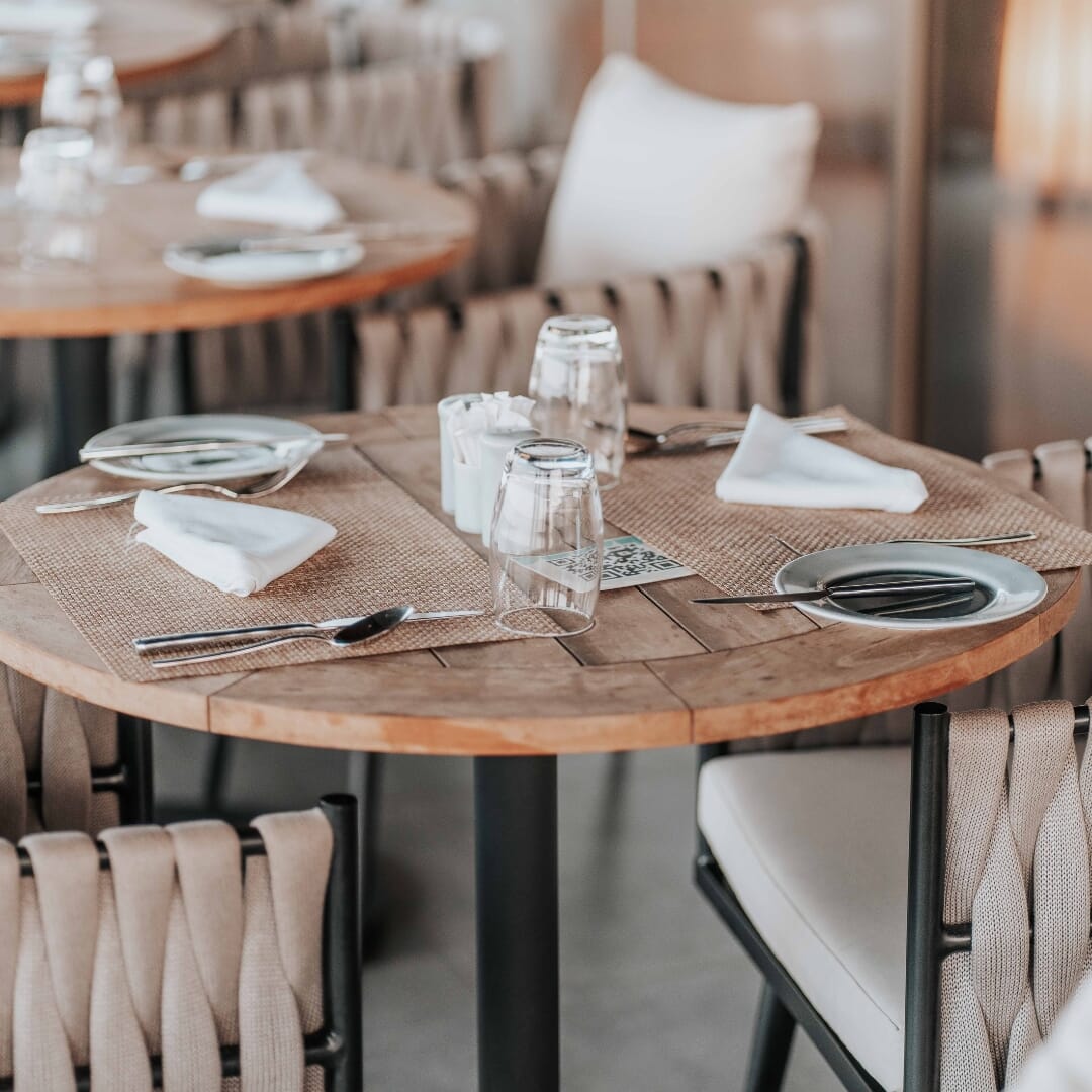 Dining layout mixing two-tops and communal tables for varied party sizes