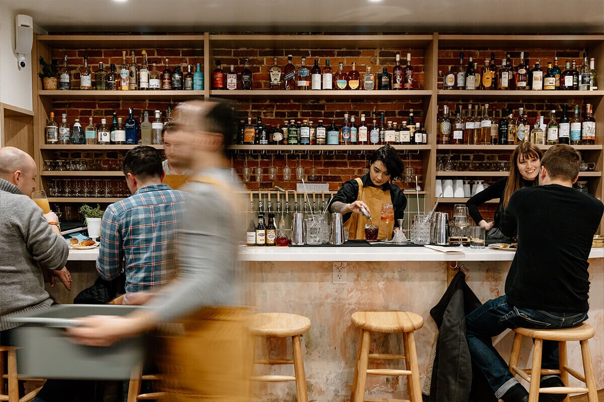 Dining room at Passerine in Lancaster, Pennsylvania, featuring rustic charm, wooden tables, and a warm ambiance, offering hyper-local and seasonal cuisine.