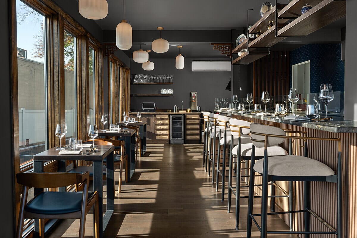 nterior of Ram & Rooster in Metuchen, NJ, featuring modern wood-accented design, open kitchen views, and stylish seating, complementing Chef Sean Yan’s innovative Chinese-inspired cuisine.