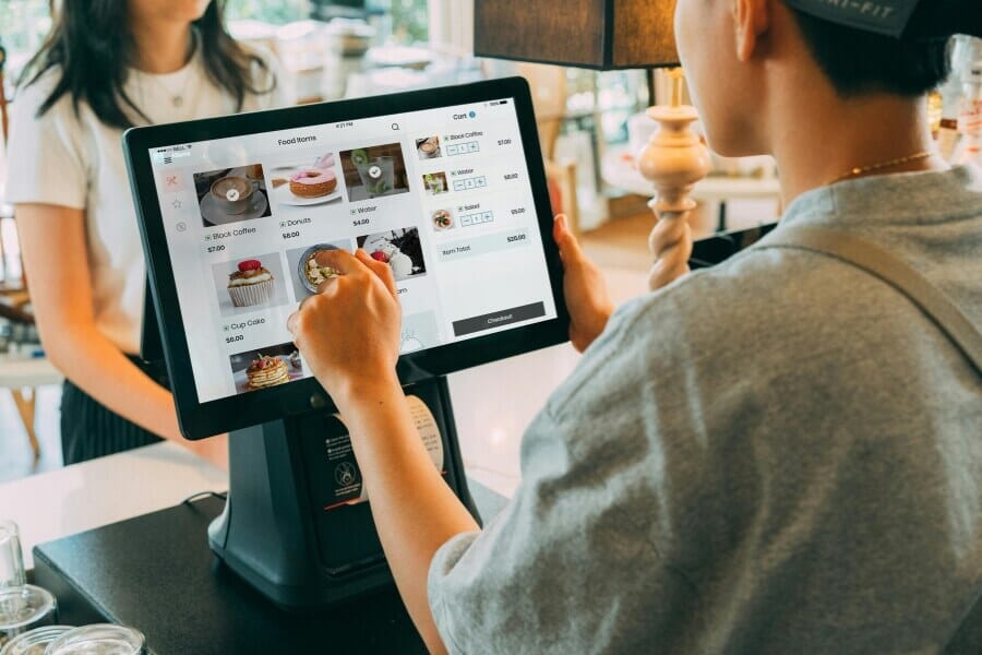 Restaurant POS system setup with touchscreen terminals and handheld ordering device