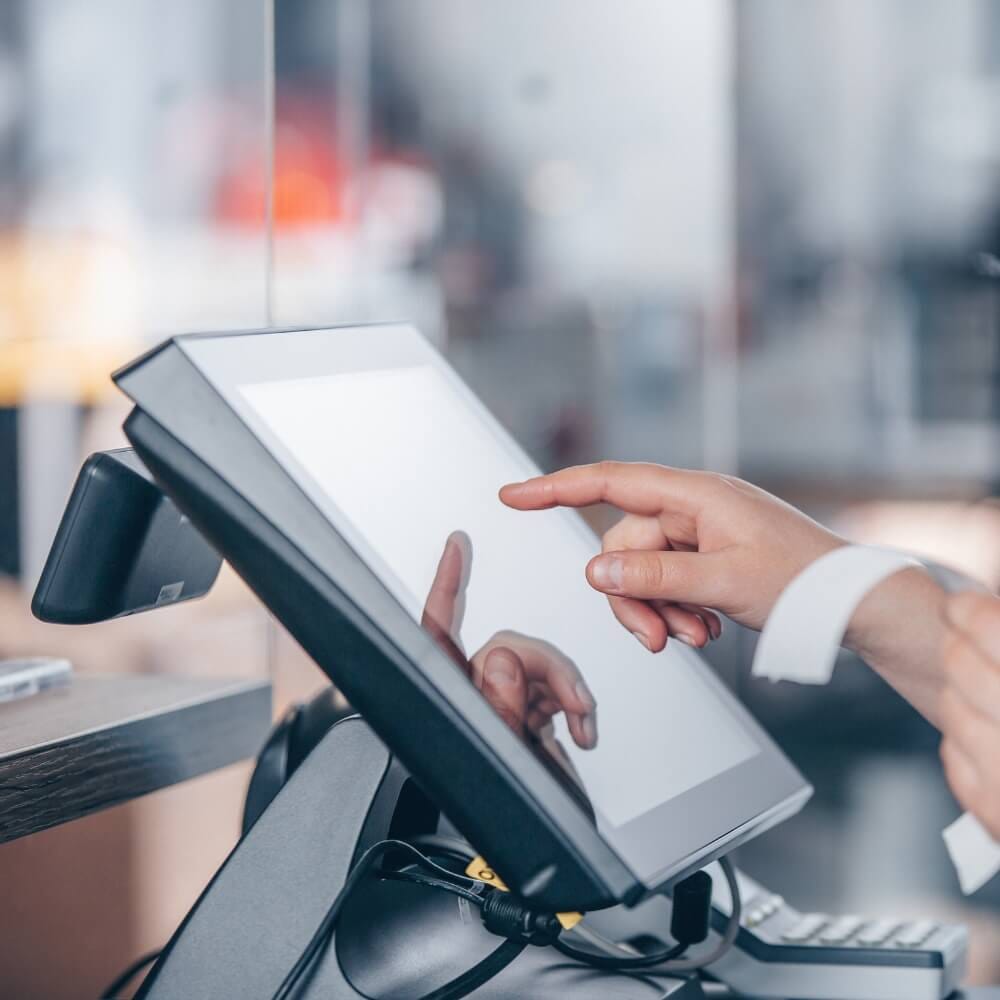 Close-up of restaurant staff operating touchscreen POS terminal during checkout