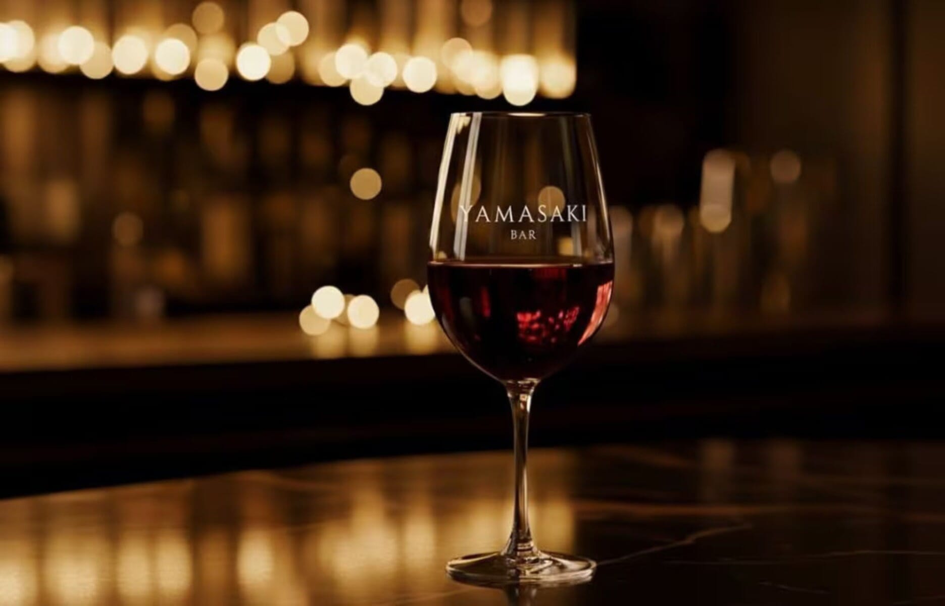 Yamasaki Bar branded wine glass with warm ambient lighting at the Financial District restaurant in Manhattan, NYC
