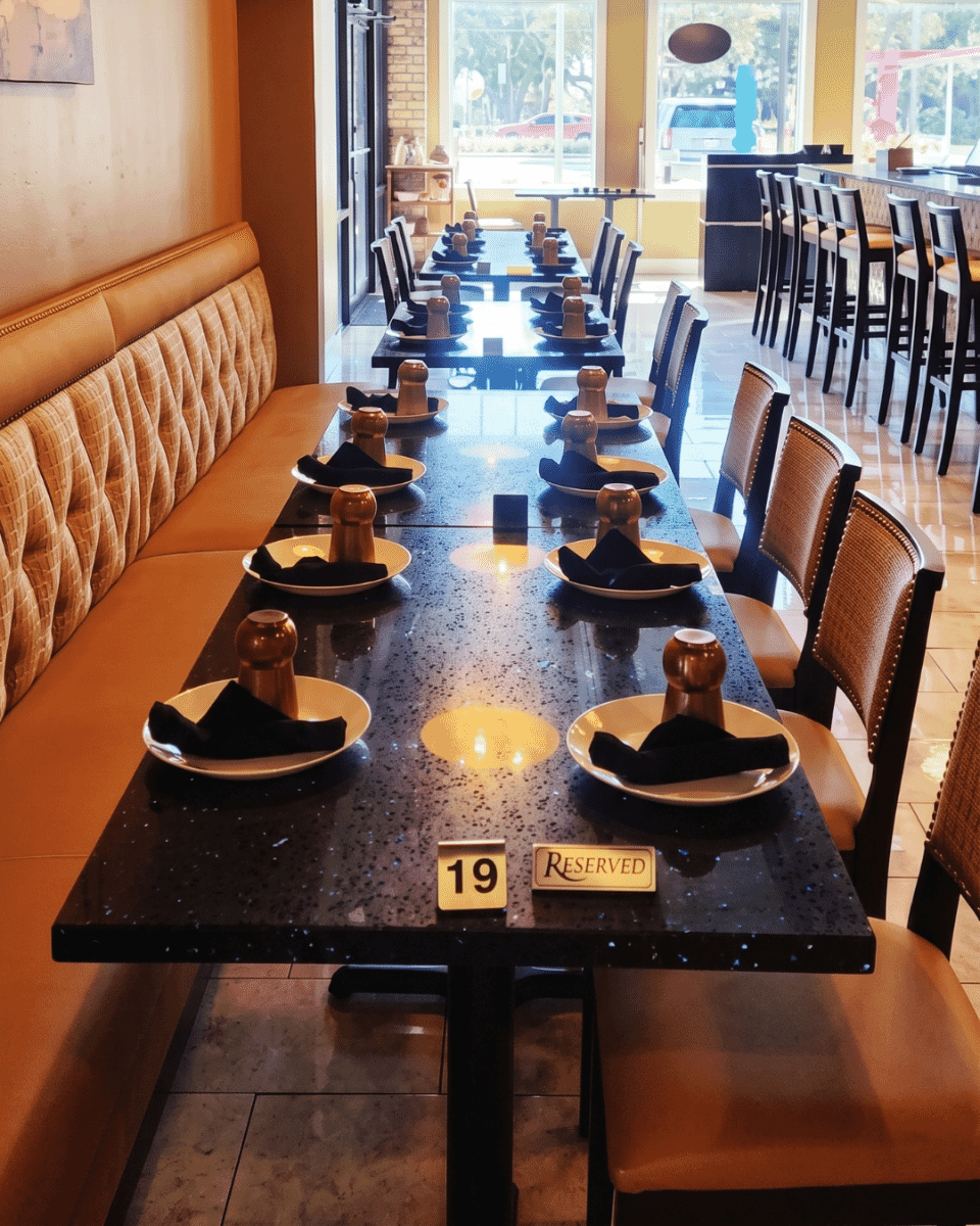 Custom L-shaped quilted restaurant booth at Taste of India with Slalom Saffron upholstered back, Repertoire Pashmina seat, walnut chairs, and Blue Galaxy quartz dining tables.