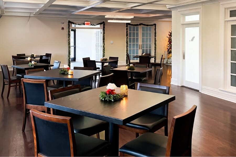 Branches Catering banquet and wedding reception space with black solid oak commercial tables, upholstered Morgan dining chairs, and flexible event seating in West Long Branch New Jersey.
