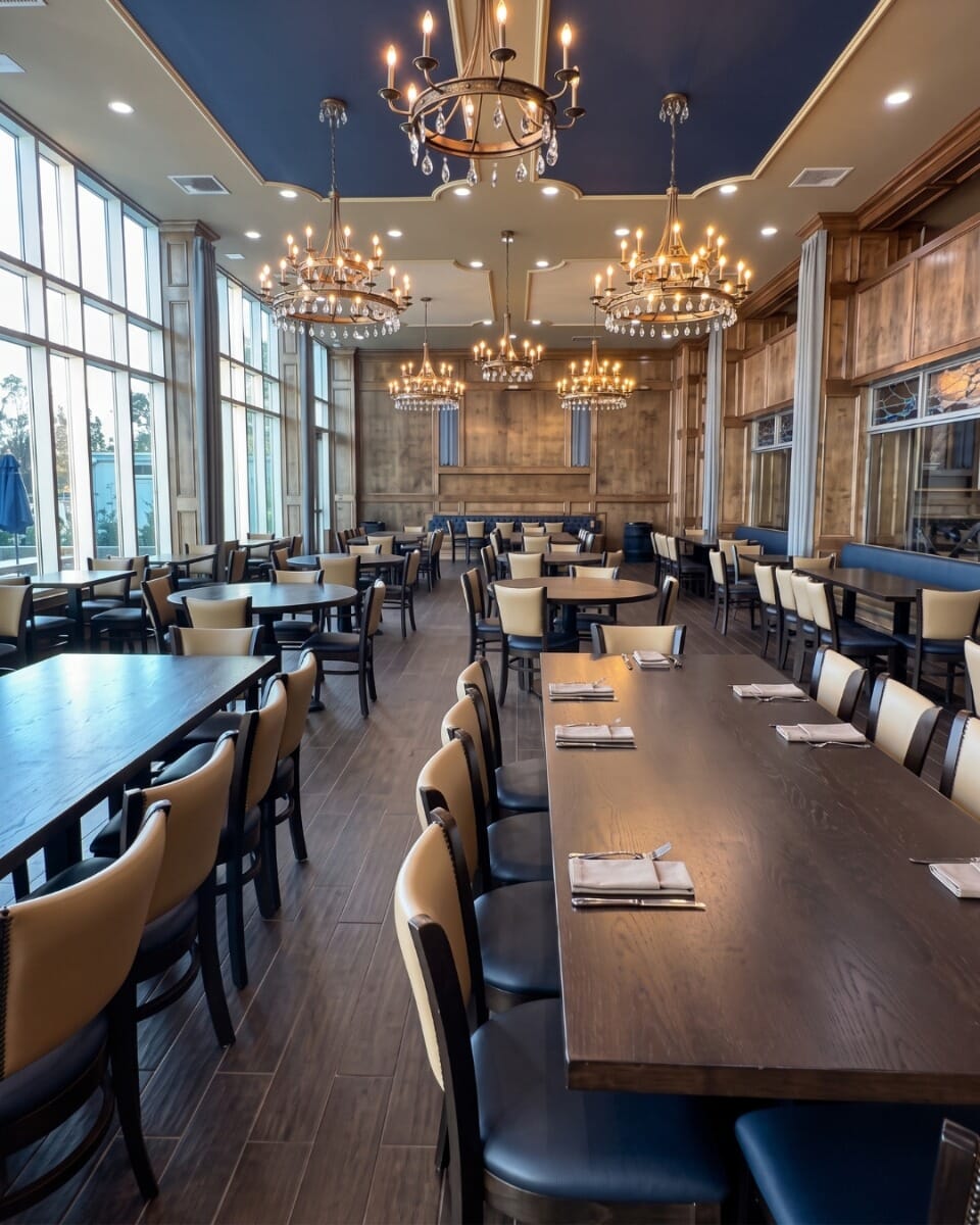 Custom upholstered dining chairs at St. Joseph by-the-Sea High School featuring Buff backs, Admiral Blue seats, walnut wood frames, and brass nailhead trim.