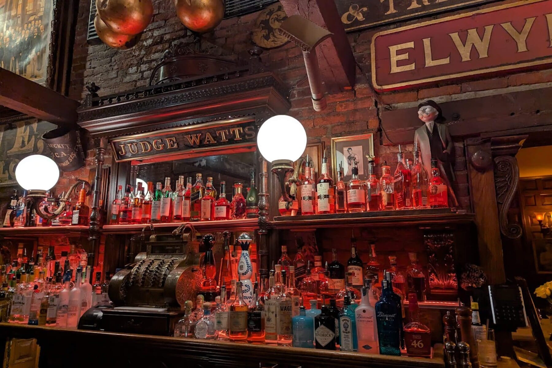 View of the bar at Saloon Cucina Italiana displaying a wide range of liquor and whiskeys and accents in old vintage designs.