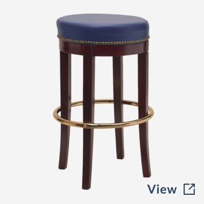 Solid walnut backless bar stool with red upholstery, brass footrest, and nailhead trim featured at Central Park Tavern in Midtown NYC.