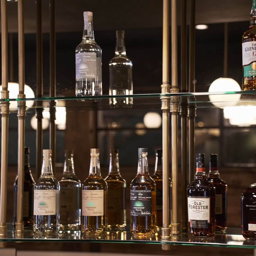 Brass-framed liquor display with glass shelves and premium spirits at Strickland’s Steakhouse bar.