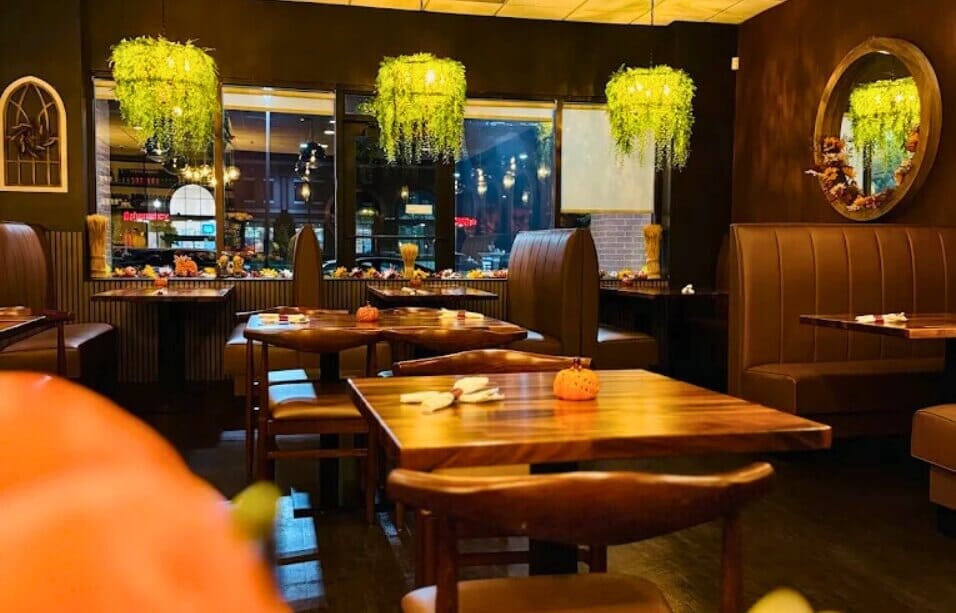 Thai Season dining room with chestnut channel-back booths, walnut tables, wood chairs and greenery chandeliers.