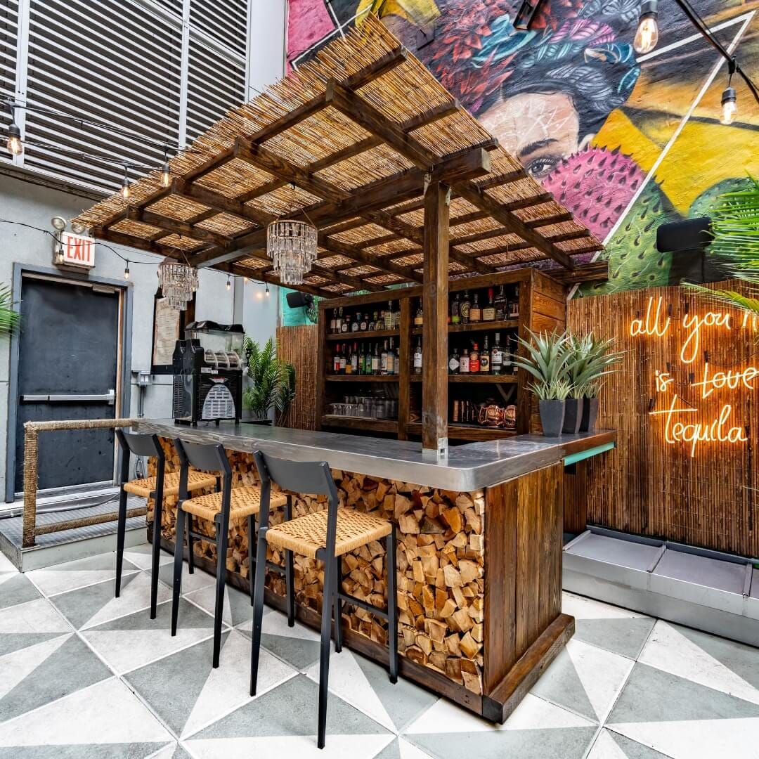Vida Verde rooftop with colorful murals, bar seating, and festive string lights