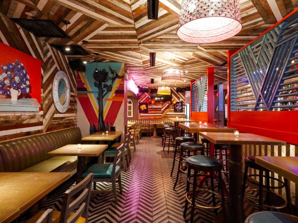 Vida Verde layout with colorful chairs, solid wood tables, and rooftop-ready seating across three floors.