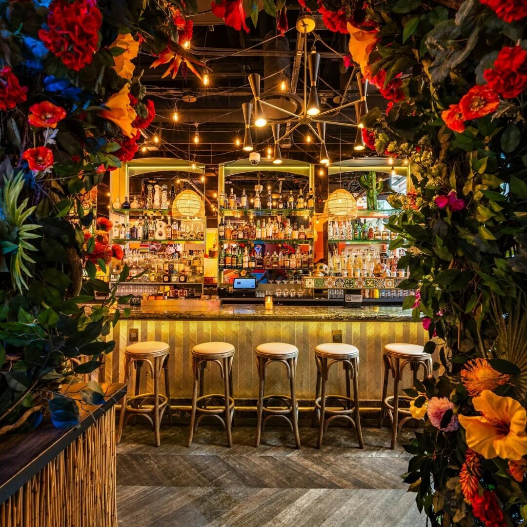 Main dining room at Vida Verde with vibrant Mexican-inspired decor, wood tables and upholstered chairs