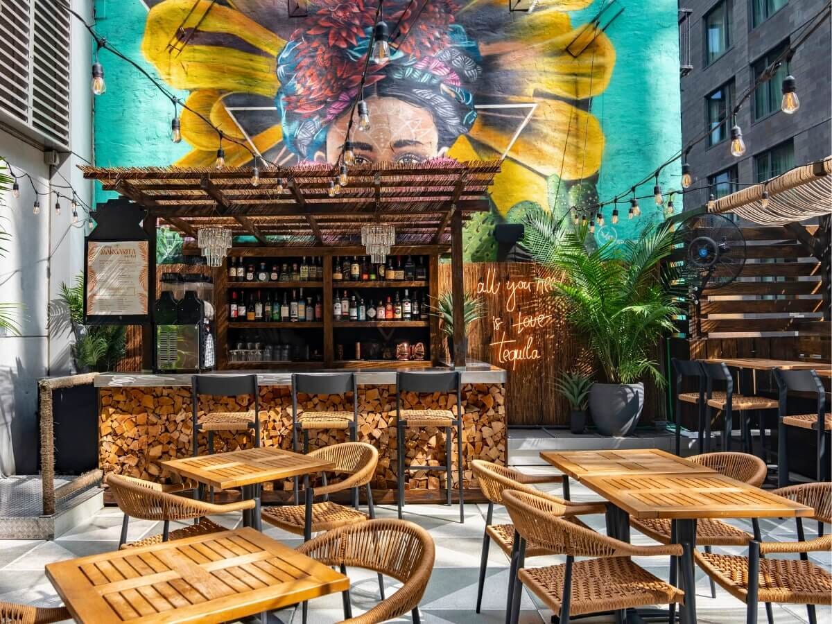 Vida Verde’s Midtown Manhattan dining room with colorful chairs, wooden tables, and vibrant murals.
