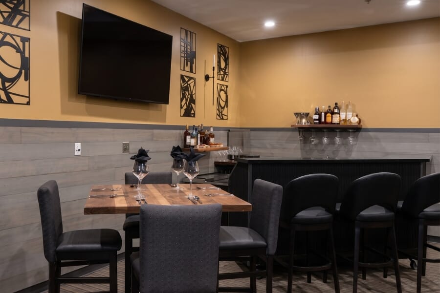 Wine display at Italian Chophouse on Lake Oconee with surrounding dining room, upholstered restaurant seating, and dark commercial furniture.