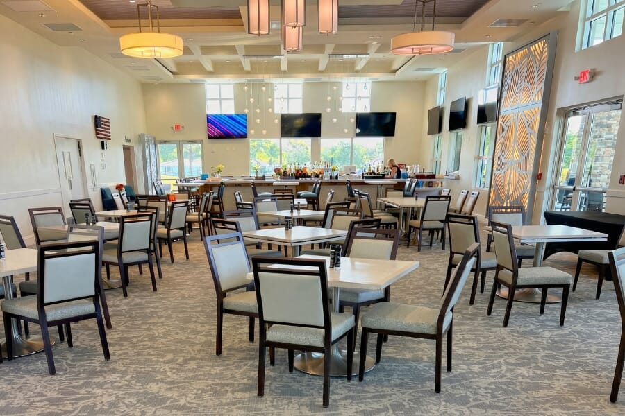 Banquet and clubhouse dining space at Country Club of Coral Springs featuring custom upholstered banquet chairs and coordinated dining tables.