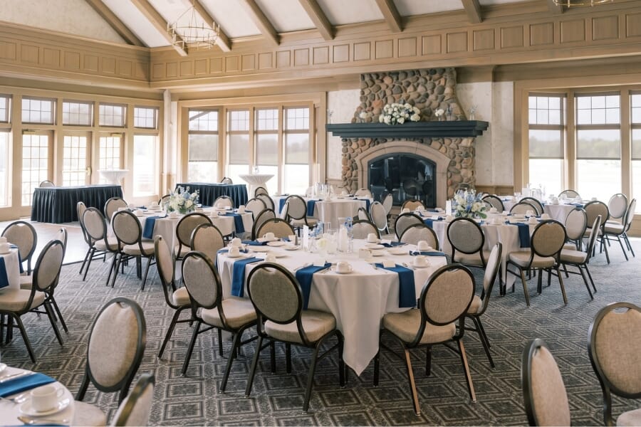Rush Creek Golf Club MacMillan Ballroom in Maple Grove Minnesota featuring Eliseo teardrop-back banquet chairs with neutral upholstery and Bronze Sparkle aluminum frames arranged for a wedding reception.