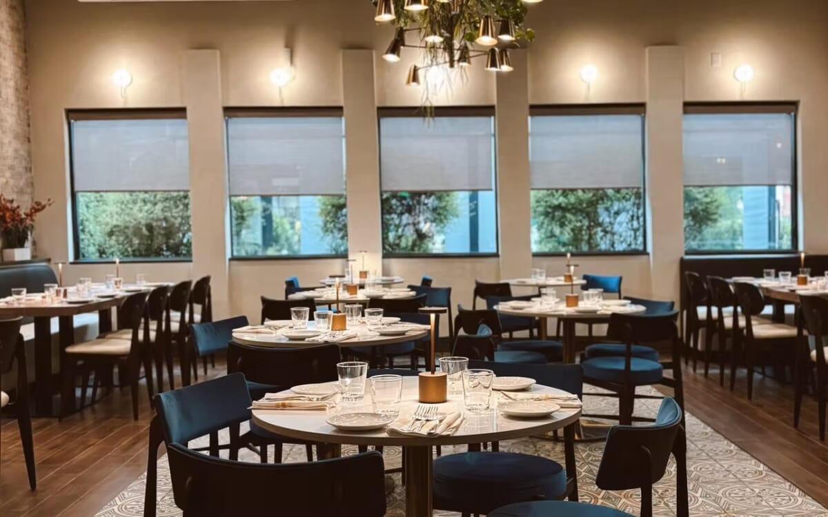 Restaurant ambiance at Villaggio Iccara with layered table finishes, elegant base details, and warm hospitality design.